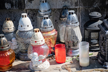 Many cemetery candles near stone wall in november, all saints day