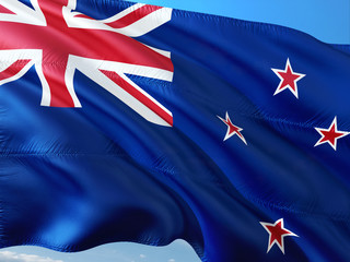 Flag of New Zealand waving in the wind against deep blue sky. High quality fabric.