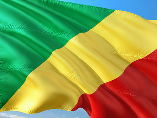 Flag of Republic Of Congo waving in the wind against deep blue sky. High quality fabric.