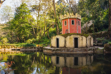 Fototapeta na wymiar Tower in the pond. Park of the Palacio Nacional de Pena, Sintra