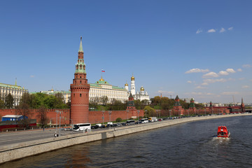Obraz premium View of the Moscow Kremlin and Moscow river in spring. Picturesque city panorama with blue sky and tourist boat, travel in Russia