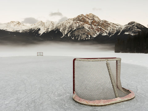 A Hockey Net On Frozen Pyramid Lake With The Rugged Canadian Rockies Mountain Range In The Background, Jasper National Park; Alberta, Canada
