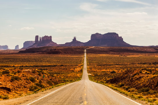 A Road Leading To Rugged Rock Formations In The Desert; Arizona, United States Of America