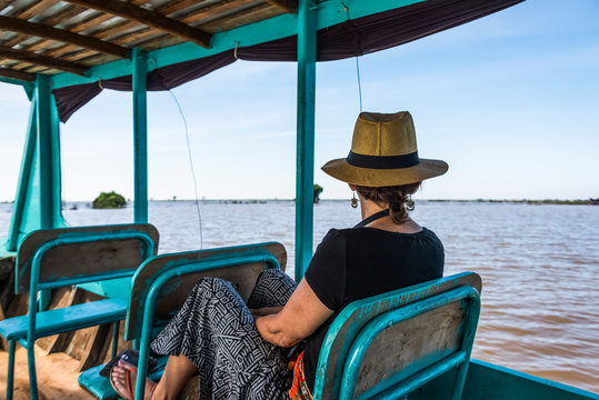 A Woman Sits On A Boat Looking Out At The Water As It Tours Down A River; Siem Reap Province, Cambodia