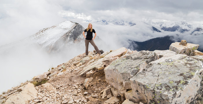 A Female Hiker Poses Alone For An Adventurous Portrait At The Peak Of A Mountain On The Hiking Trails Of Kicking Horse Mountain In The Rocky Mountains; British Columbia, Canada
