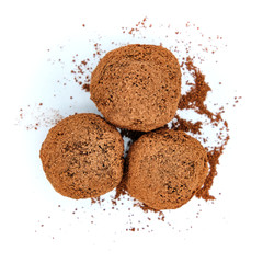 Homemade truffles in the sprinkles of cocoa. Delicious chocolates close up. Chocolate candy handmade - top view, isolate on white background.