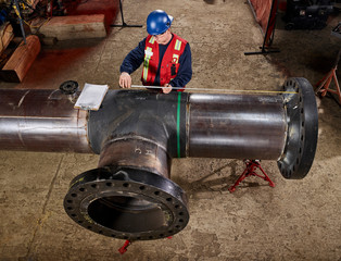 A Tradesman Measures A Pipe For Documentation; Edmonton, Alberta, Canada