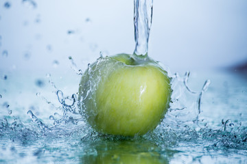 Green apple with freezed water splash