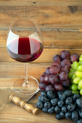 Glass of red wine with three kinds of grapes