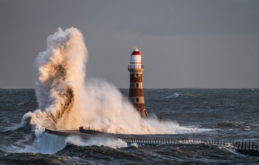 Waves Splashing Against Roker Lighthouse At The End Of A Pier; Sunderland, Tyne And Wear, England