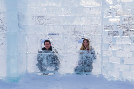A Young Tourist Couple Poses Inside Of An Ice Castle Build On The Ice At Lake Louise In Banff National Park; Lake Louise, Alberta, Canada