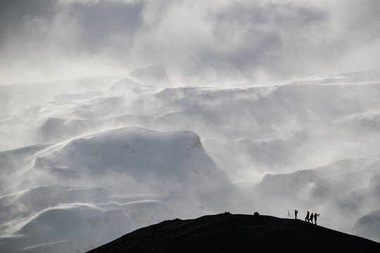 Group Of Photographers Silhouetted Against The Snow Laden Mountain; Iceland