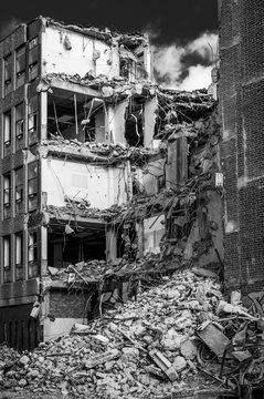 A building under demolition with a pile of rubble on the ground and floors of the building exposed; Newcastle Upon Tyne, Tyne and Wear, England