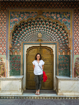 A female tourist stands in front of the Peacock Gate, City Palace; Jaipur, Rajasthan, India