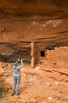 Hiker taking a photograph, Ancestral Pueblo, up to 1,000 years old, Bears Ears National Monument; Utah, United States of America