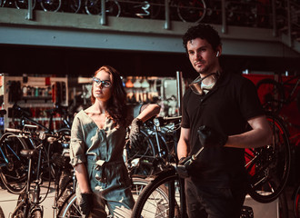 Young master and his attractive apprentice are taking a break after repairing a bicycle at workshop.
