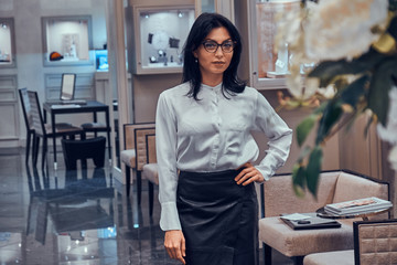 Elegant jewellery boutique's assistant is waiting for customers in her posh shop.