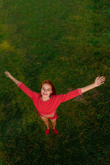 Top view photo of happy healthy sportswoman on the background of green grass