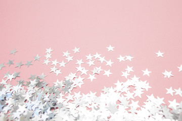 Star-shaped confetti scattered on a pink background. Celebration and party, concept. Copy space