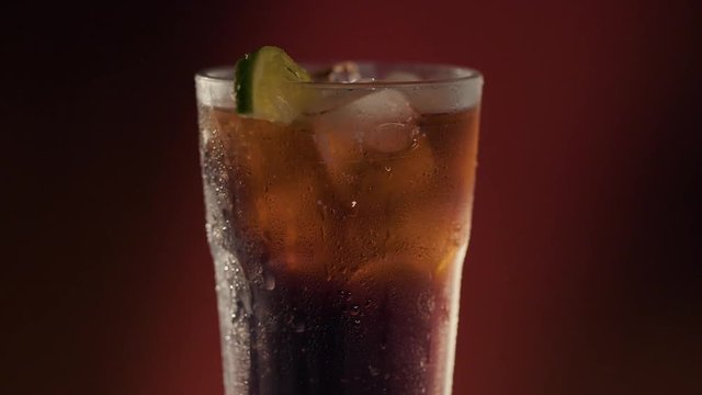 Ice cold refreshing beverage spinning over a dark background,