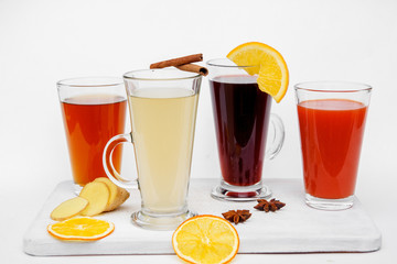 Hot tea in glass mug with lemon, honey and spices at white. Healthy drink. Close up.