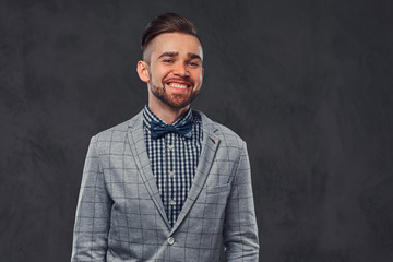 Fototapeta premium Studio shoot of smart smiling man in checkered blazer and shirt with bow.