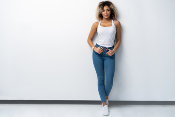 Full length portrait of stylish young black woman standing on white background. © opolja