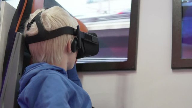 Malik blond with glasses of virtual reality. The child presents himself to the subway train drivers. He sits in a chair and looks into his glasses vr