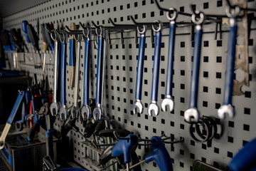 Repairman's workshop, close-up low-key image. Well organised workplace of a mechanic, rows of spanners and other tools, close-up view - obrazy, fototapety, plakaty