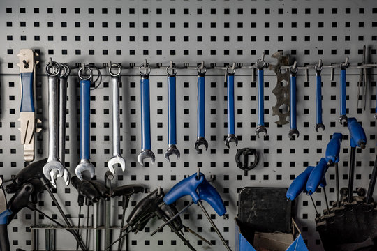 Repairman's workshop, close-up low-key image. Well organised workplace of a mechanic, rows of spanners and other tools