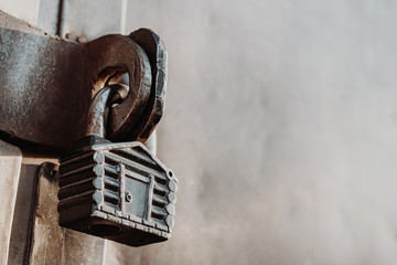 Padlock in the form of a hut hangs on the hinges of the closed gate. Metal gates.