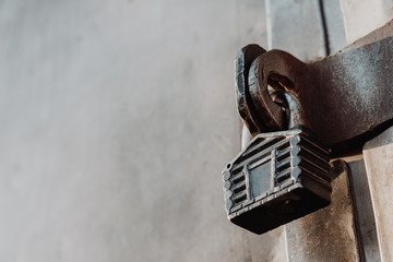 Padlock in the form of a hut hangs on the hinges of the closed gate. Metal gates.