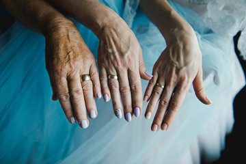 Three generations - daughter, mother and grandmother, three hands , top view, together with wedding...