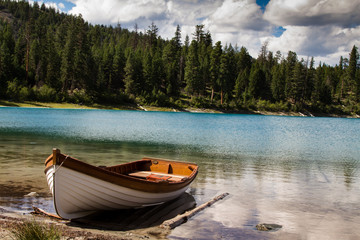Boat on the lake by trees under cloudy sky