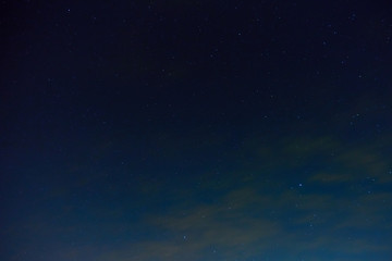 Naklejka na ściany i meble The night sky with stars and clouds. Natural background.