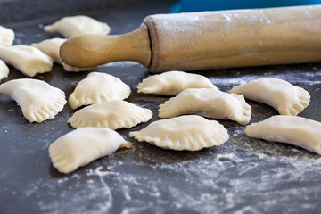 Vorbereitung auf Knödel mit Kartoffeln auf grauem hintergrund mit Nudelholz und Mehl