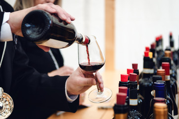 Tasting experience with a male sommelier serving a glass of traditional red dolcetto wine in Alba, Piedmont (Italy)  - 265389942