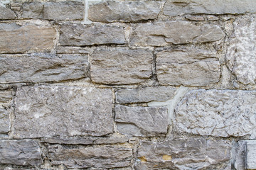 Old stone wall demonstrating masonry work; textured surface for grunge overlay