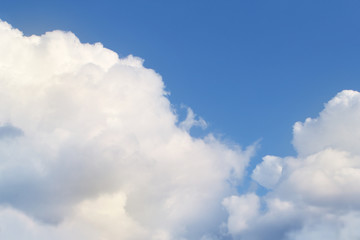 white, fluffy, cumulus clouds on a blue sky background