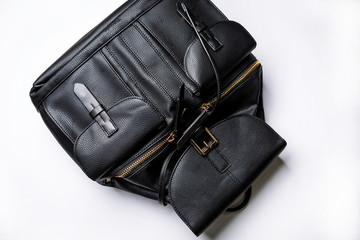 black leather backpack with golden zipper pockets on a white background