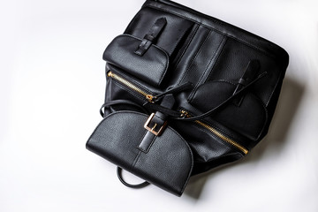 black leather backpack with golden zipper pockets on a white background