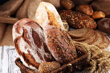 Foto op Plexiglas Assortiment van gebakken brood en broodjes op rustieke witte bakkerijtafelachtergrond © beats_