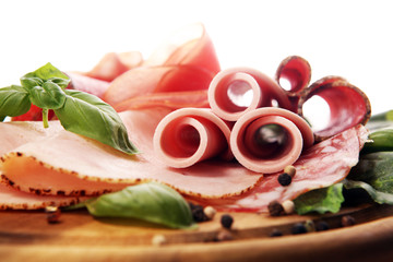 Food tray with delicious salami, pieces of sliced ham, sausages,salad and vegetable. Meat platter with selection