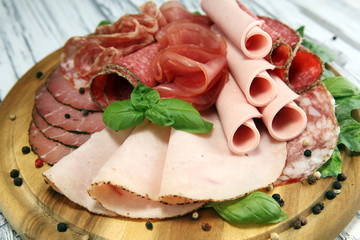 Food tray with delicious salami, pieces of sliced ham, sausages,salad and vegetable. Meat platter...