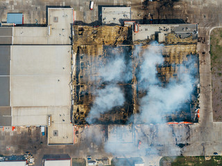 Burning industrial distribution warehouse, top view from drone