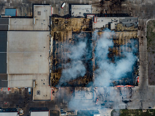 Burning industrial distribution warehouse, top view from drone