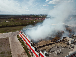 Burning industrial building. Smoke, collapsed roof, aerial view