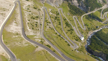 AERIAL: Flying above a scenic switchback road leading up to a mountain pass.