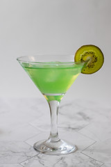 Refreshing kiwi lemonade with ice on a light background