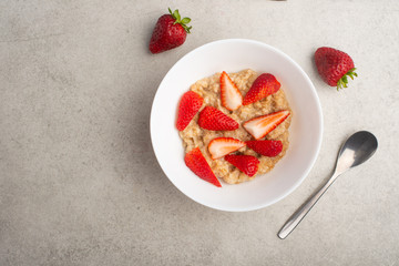 breakfast of oatmeal with strawberries, flat lay